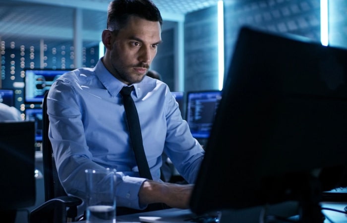 A man sitting at his desk looking at the computer.